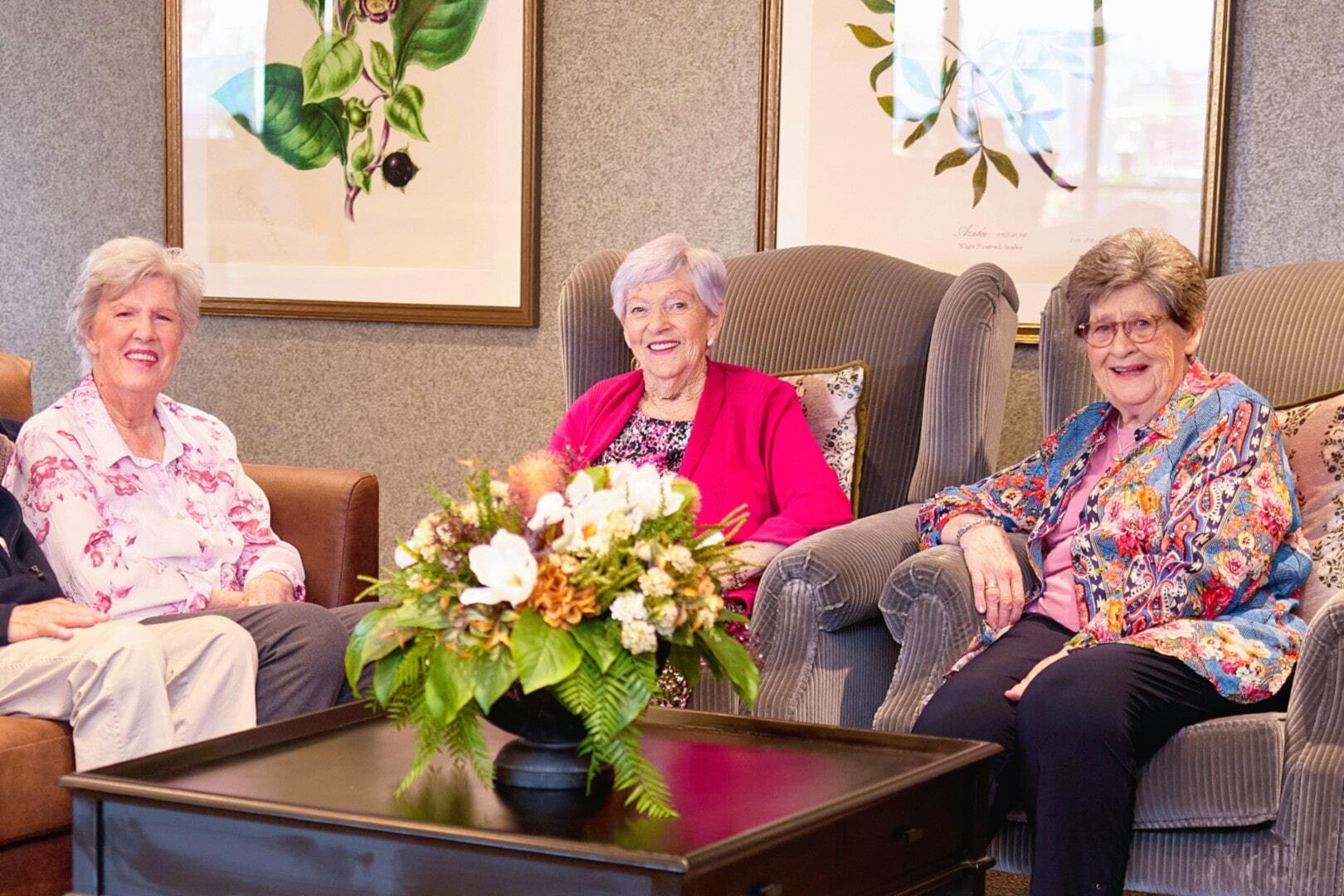 Three older ladies enjoying each other's company in pleasant indoor surroundings